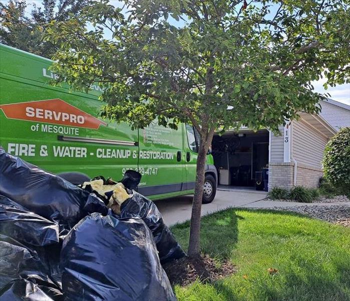 A SERVPRO Mesquite van parked in front of a home.